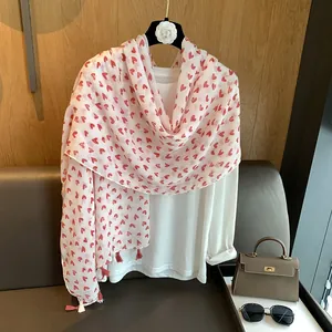 Detail of soft cotton linen shawl with red heart prints and decorative tassels
