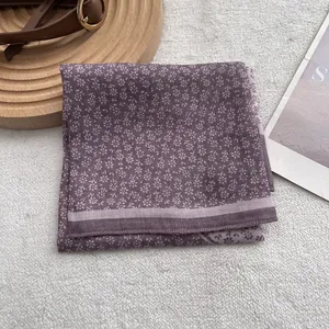Detail of purple floral square scarf with striped edges on a wooden tray setting