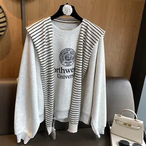 Close-up of a striped knit shawl draped over a grey Northwestern sweatshirt on a hanger