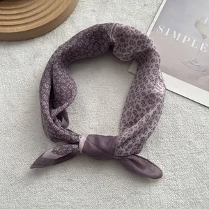 Close-up of floral purple silk scarf with elegant pattern and soft fabric texture