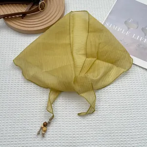 Élégant foulard en soie plissé jaune gingembre avec glands en perles de bois sur tissu