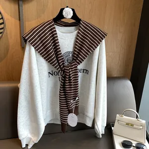 Classic striped knitted shawl styled over a gray Northwestern University sweatshirt