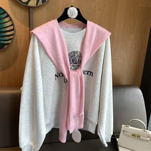 Detailed view of pink knitted shawl paired with Northwestern University sweatshirt