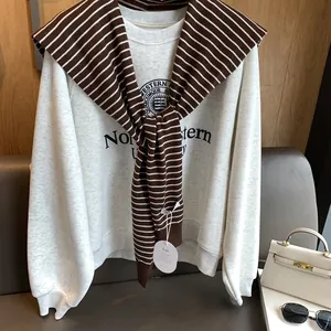 Detail of striped knit shawl draped over a Northwestern University sweatshirt with tag