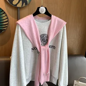 Close-up of pink hollow knit shawl layered over a grey Northern sweatshirt on hanger