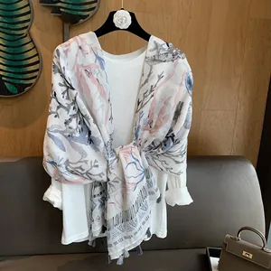 Detail of coral print cotton linen scarf with gray fringe tassels on a hanger
