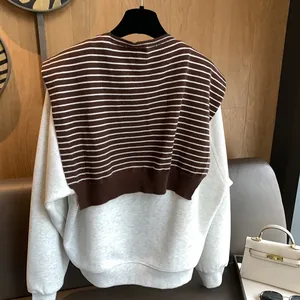 Classic striped knit vest paired with cream long-sleeve sweatshirt for women