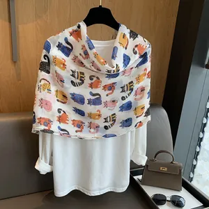Detail view of cotton linen scarf with colorful cartoon cat print styled with white shirt