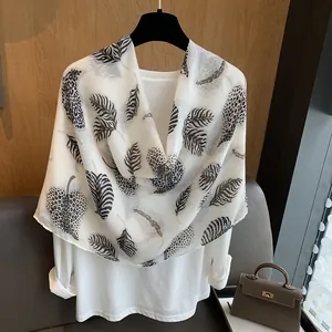 Lightweight white scarf featuring large leaf patterns with leopard and zebra print textures
