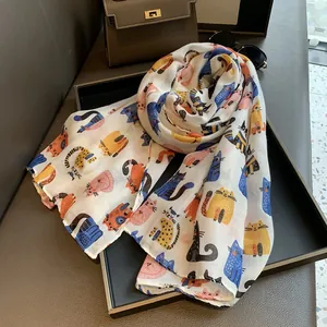 Close-up of lightweight linen scarf featuring vibrant cartoon cat prints on white fabric