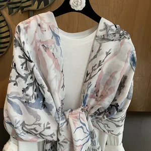 Detail of coral and starfish print on a lightweight beach shawl with semi-sheer texture