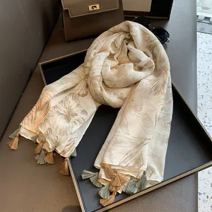 Lightweight cotton linen scarf with floral print and fringe tassels on a display tray