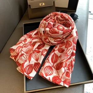 Dettaglio di foglie rosse su foulard di seta con eleganti accenti in foglia d'oro