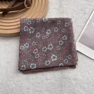 Detail of vintage floral cotton scarf with red-brown fabric and white flowers