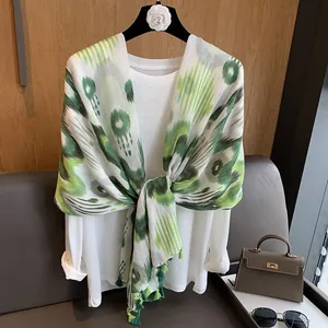 Detail of green tie-dye cotton linen scarf showing ethnic patterns and tassel edges