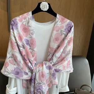 Vue détaillée du châle floral rose avec bordures à franges et motifs coquelicots