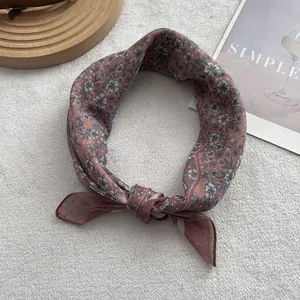 Detail of floral chiffon neck scarf with retro flower pattern on soft white background