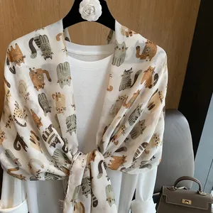 Detail of white cotton linen scarf with colorful cartoon cat patterns and soft texture
