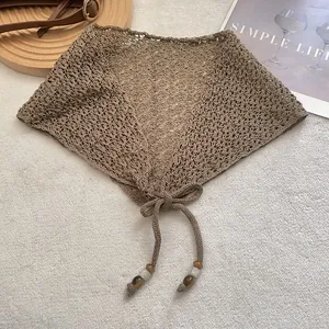 Détail de l'écharpe de taille en tricot ajouré avec maille crochetée et cordon à perles