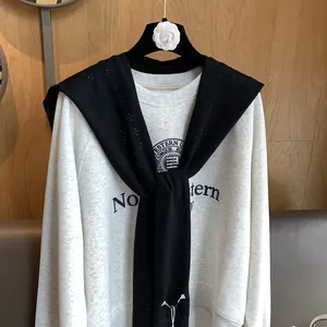 Detail of grey Northwestern sweatshirt with black knitted shawl over high-end coat hanger