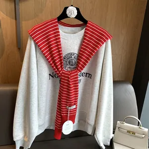 Detail of grey sweatshirt with Northwestern University print and red striped knit shawl