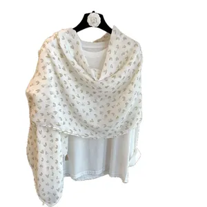 Lightweight white scarf with brown heart pattern and fringe detail on white shirt
