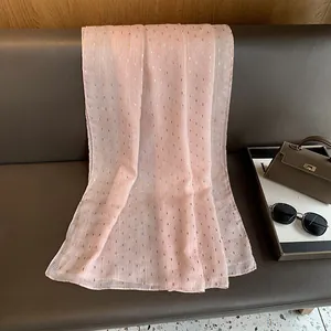 Close-up of pink lightweight shawl with gold foil patterns and stripe textures