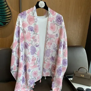 Détail d'une écharpe fleurie rose clair avec glands élégants et texture de tissu voile