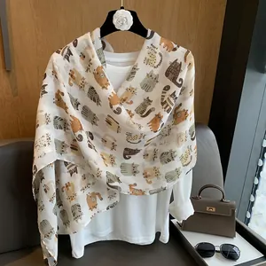 Close-up of translucent scarf featuring cute cartoon cat patterns on a soft white fabric