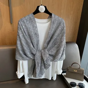 Close-up of black and white striped linen shawl with elegant gold foil polka dot details