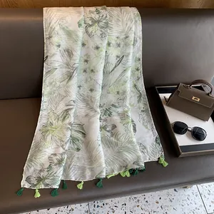 Close-up of tropical leaf print scarf with elegant dual-tone green fringe tassels