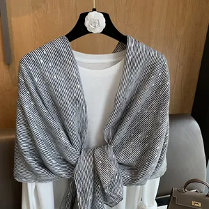 Detailed close-up of soft black and white striped shawl with elegant gold foil stamping