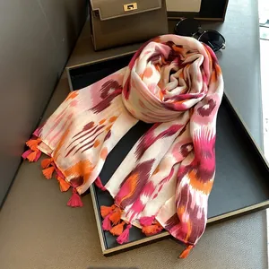 Close-up of lightweight ikat print scarf with decorative tassels and colorful ethnic pattern