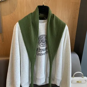 Détail d'un châle en laine tricoté vert herbe avec des motifs ajourés complexes