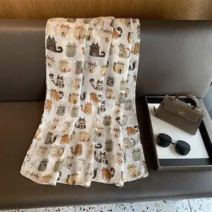 Chic linen cotton scarf with cute cartoon cat prints draped over a modern sofa