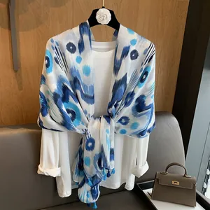 Detail of blue geometric print linen shawl with fringe on a stylish hanger display