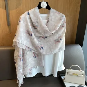 Detailed texture of cotton linen scarf with elegant leaf print and white fringe trim