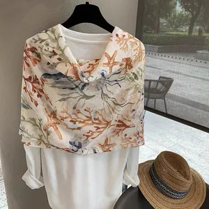 Detail of sheer coral reef print scarf draped on a hanger for a beach resort look