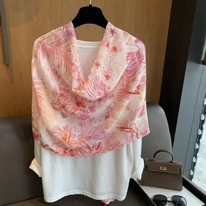 Detail of a lightweight floral scarf with palm leaf prints on a casual outfit