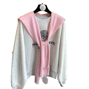 Grey Northwestern University sweatshirt paired with a pink hollow knitted shawl wrap