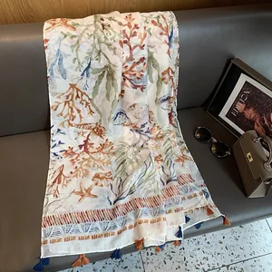 Detail of coral and starfish print cotton linen scarf with elegant blue tassel trim