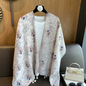 Close-up of floral print linen shawl with delicate white tassels and hand-painted patterns