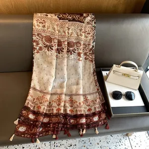 Dettaglio di sciarpa bohémien con nappe eleganti e texture con stampa etnica