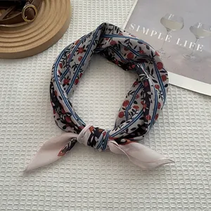 Vue détaillée d'un foulard crème à motif baies rouges sur un tissu gaufré blanc