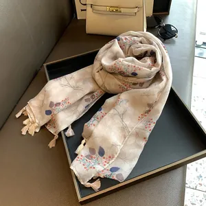 Detailed view of floral berry print scarf with elegant tassels on a luxury tray
