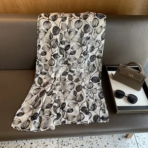 Dettaglio della sciarpa vintage con stampa in lamina d'oro e ricamo a foglie metalliche