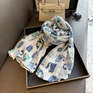 Detail of cotton linen scarf featuring blue cartoon cat prints and soft breathable texture