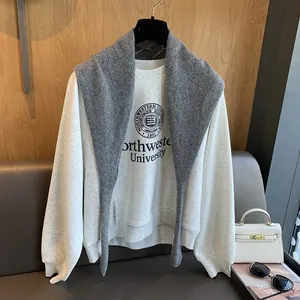 Détail du châle en laine gris foncé à carreaux sur un sweat-shirt blanc à lettres
