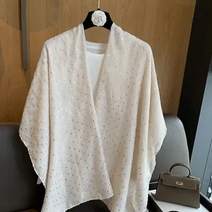 Detail of white shawl with elegant gold metallic stripes over a white T-shirt