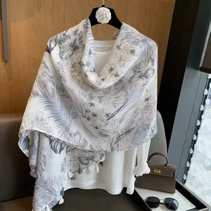 Close-up of lightweight cotton scarf featuring tropical floral patterns and fringe details